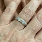 Anillo de banda con diseño de margarita y volutas