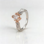 Elegante anillo de flor de dos tonos, chapado en plata, con circonitas engastadas