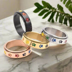 Thea - Anel anti-stress giratório com patinhas arco-íris
