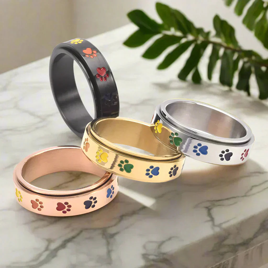 Thea - Anel anti-stress giratório com patinhas arco-íris