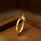 Elegante anillo dorado de banda con piedra de turquesa lisa