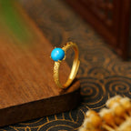 Elegante anillo dorado de banda con piedra de turquesa lisa