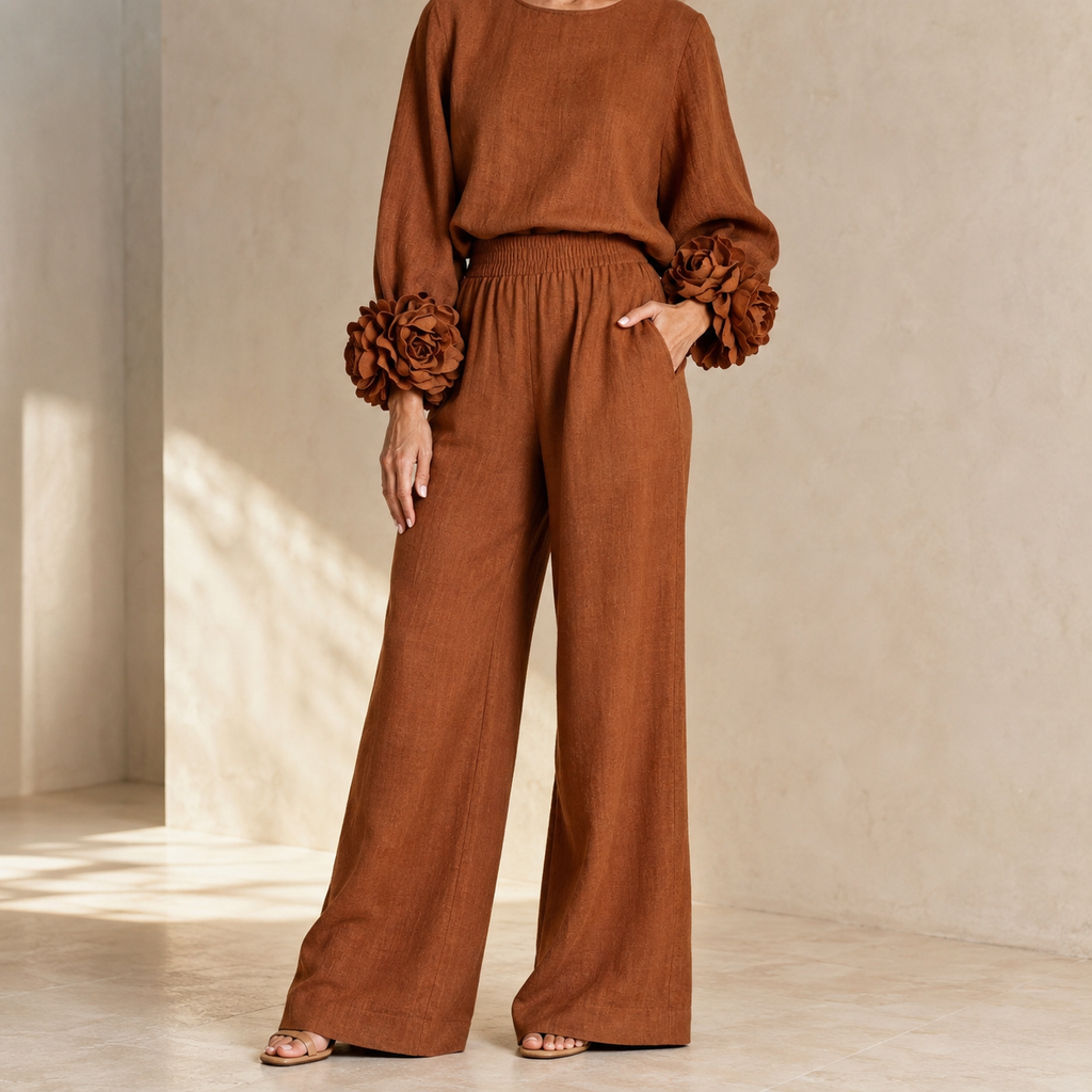 Rust knit top and wide leg pants in a sunlit room with hand in pocket